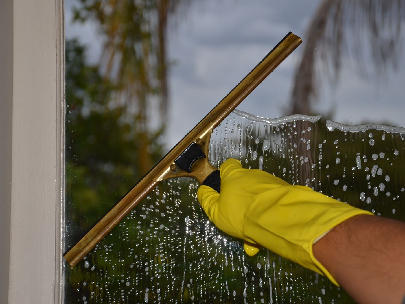 Window being cleaned with a squeegee in Singapore by Cleanitize